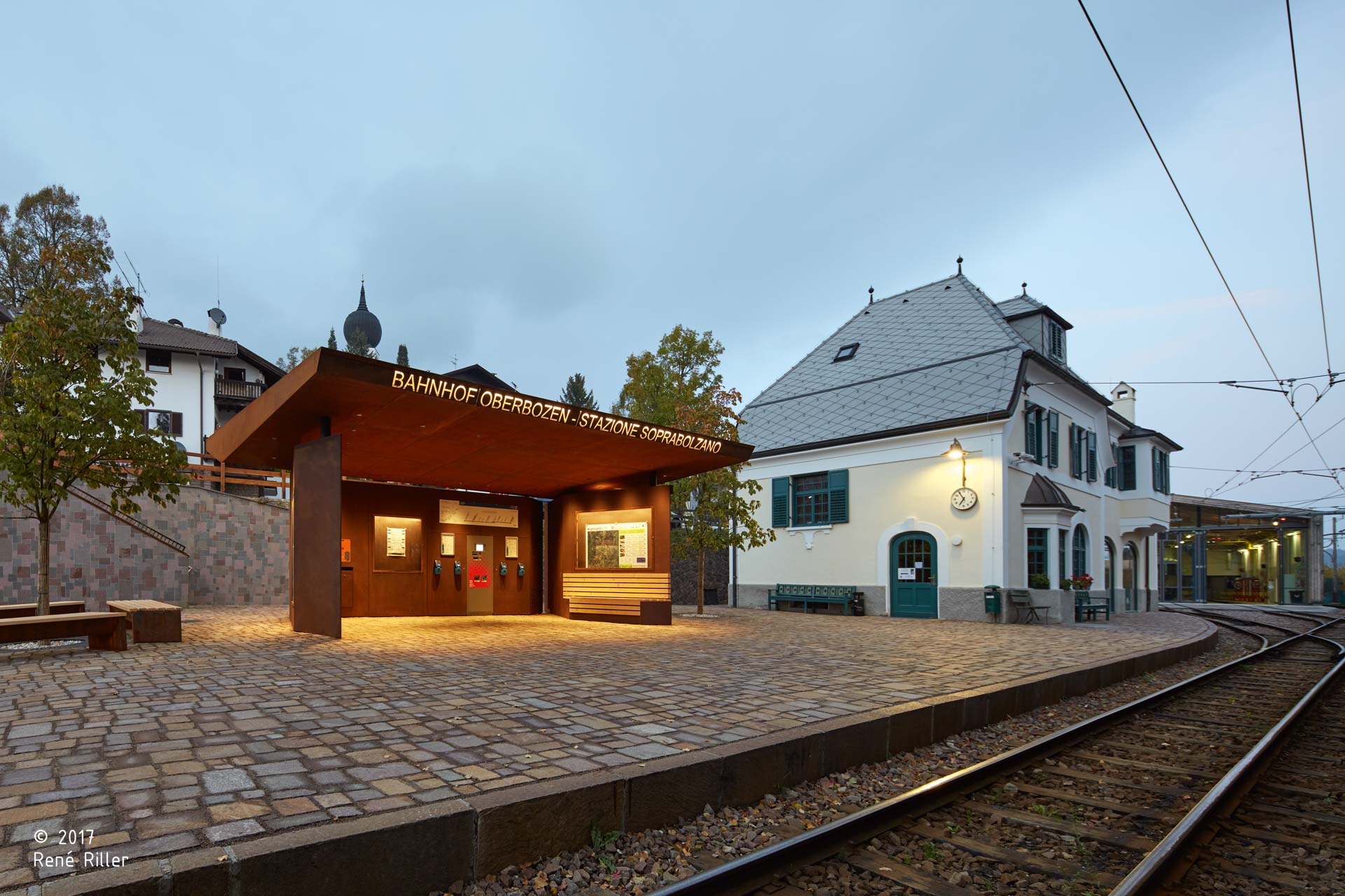 Ing.-Josef-Riehl Platz; Bahnhofsplatz; Südtirol; Stützmauer; Tradition von Renon; Porphyr; Trockenmauer; Bahnhof des Jahres 2018; monovolume architecture + design; Architektur Südtirol; moderne Architektur; monovolume Architekten